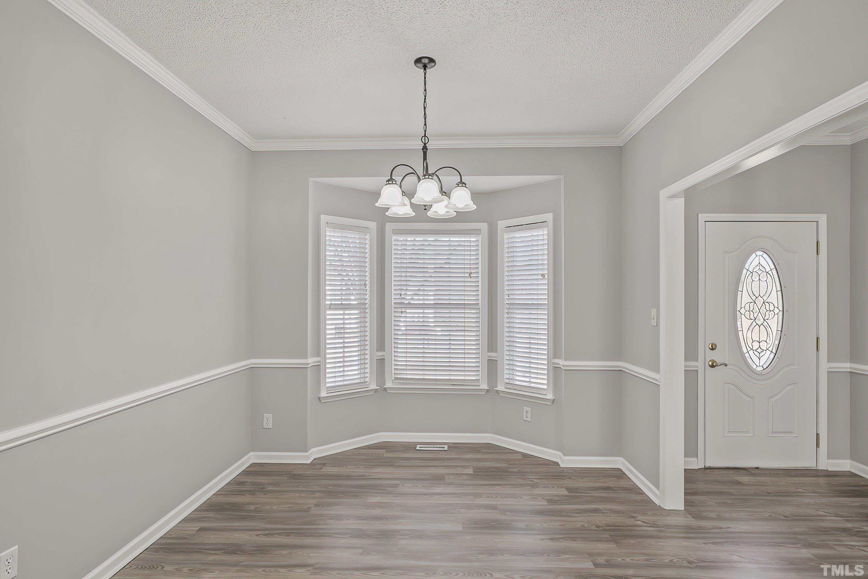 1008 Linden Crest Road Raleigh, NC 27603 - Photo 7 of 37 a view of an empty room with window and wooden floor