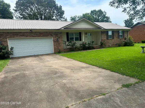 a front view of a house with a garden and plants