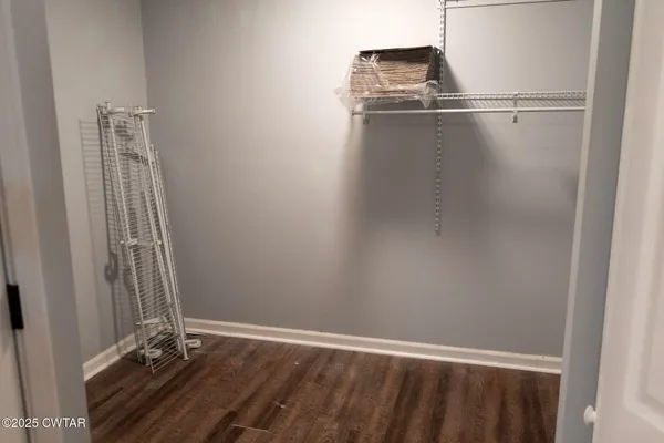 a view of a small space with wooden floor and a window