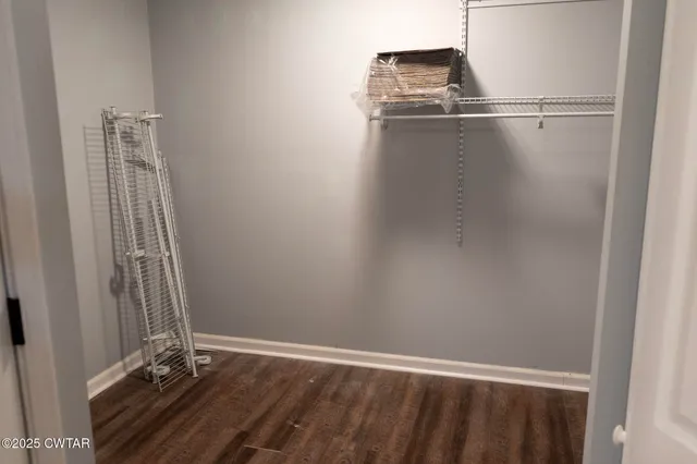 a view of a small space with wooden floor and a window