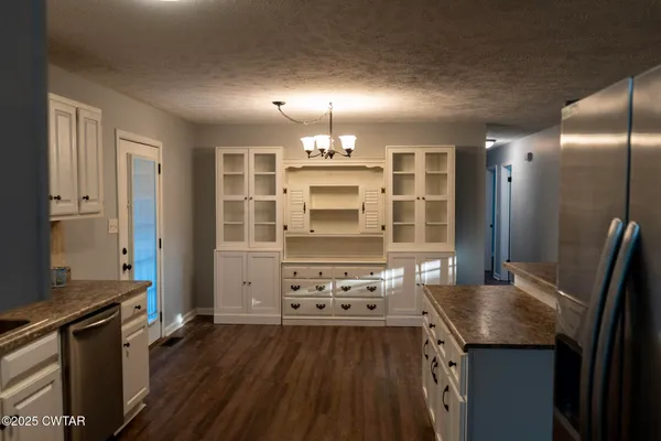 a kitchen with granite countertop a stove and a refrigerator