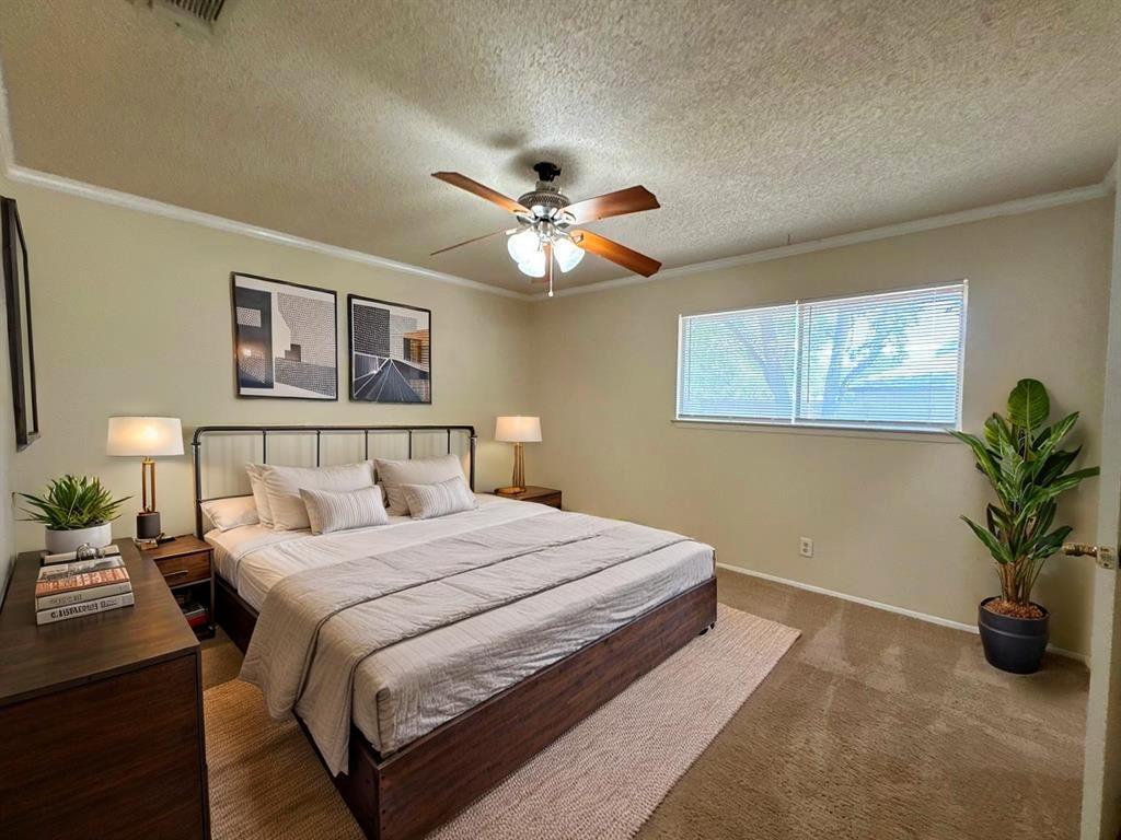 5905 Burrough Drive Austin, TX 78745 - Photo 33 of 40 a bedroom with a large bed and a chandelier