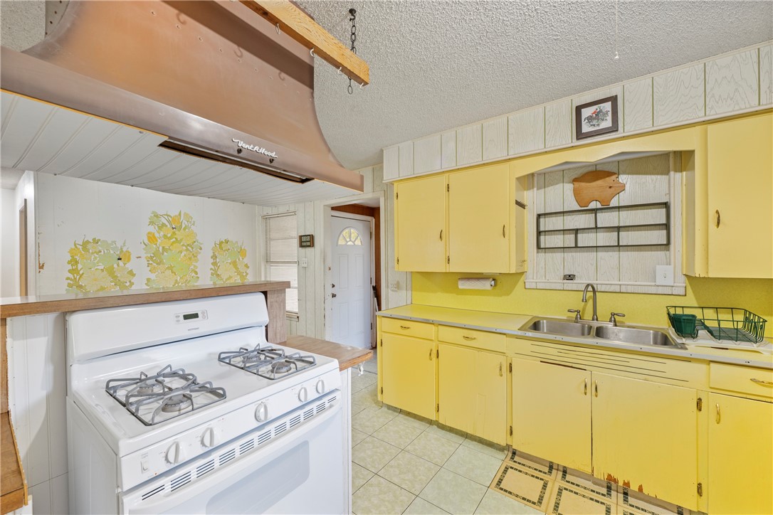12844 Hearn Road Corpus Christi, TX 78410 - Photo 9 of 34 a kitchen with a sink a stove cabinets and a window