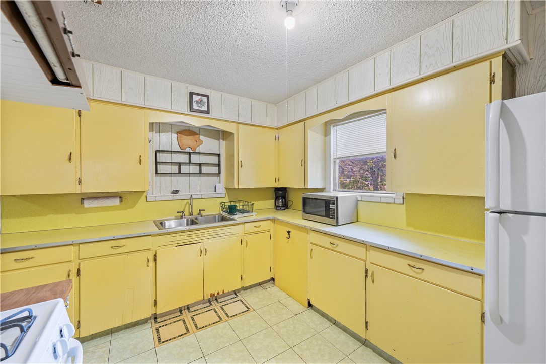 12844 Hearn Road Corpus Christi, TX 78410 - Photo 10 of 34 a kitchen with a sink a refrigerator and window