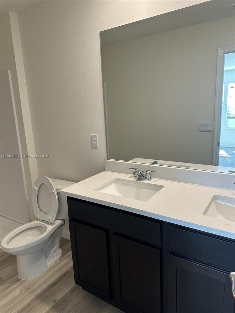 8196 Southwest 67th Avenue Ocala, FL 34476 - Photo 10 of 13 a bathroom with a sink a toilet a mirror and vanity