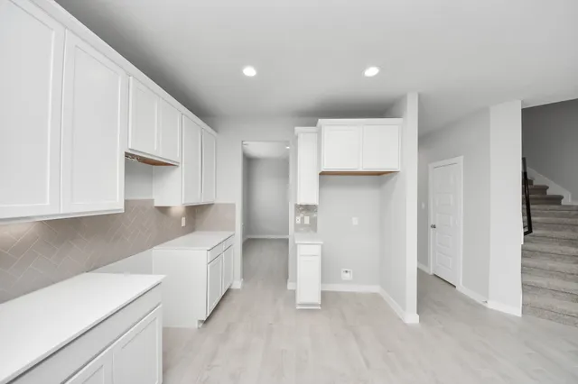 a kitchen with a sink and chairs