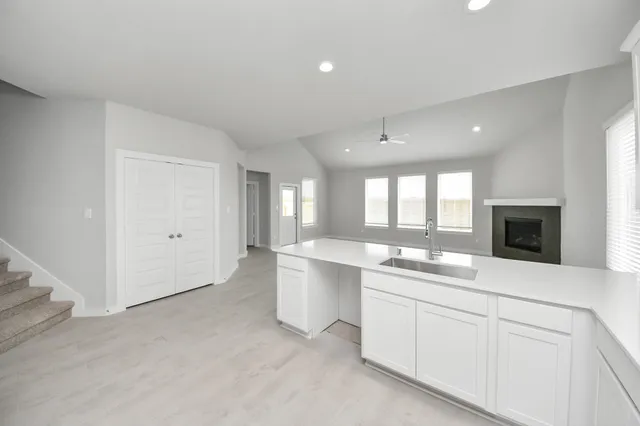 an empty room with windows and fireplace