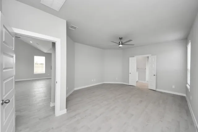 a bedroom with a bed a mirror and a flat tv screen on a dresser