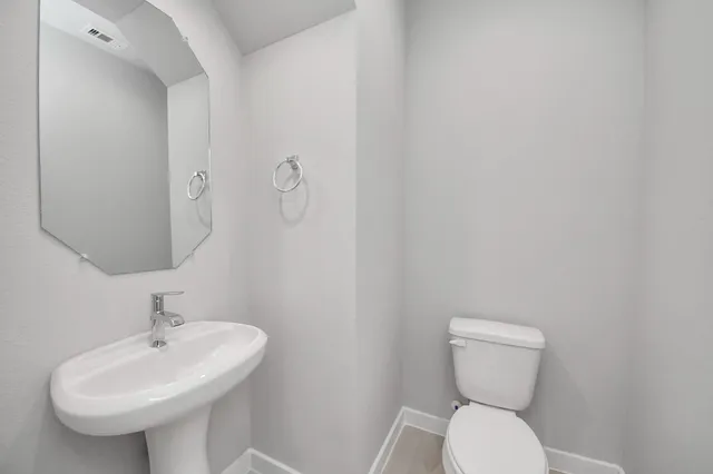a bathroom with a sink a toilet and mirror