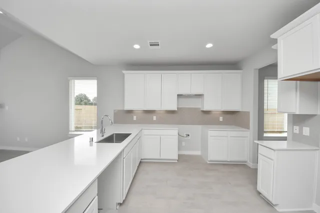 a large white kitchen with cabinets