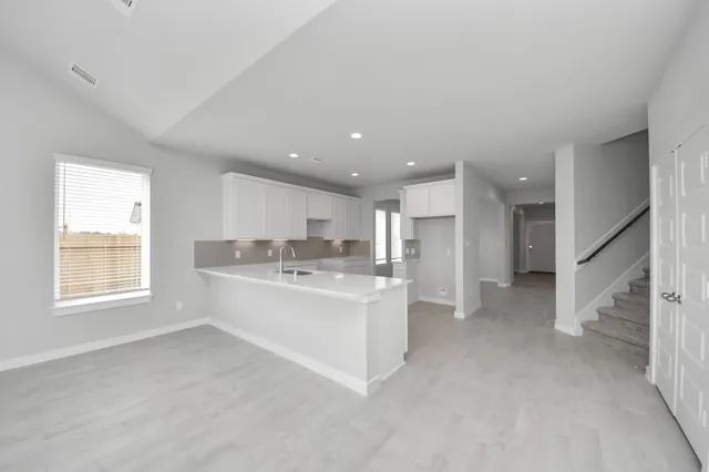 a kitchen with white cabinets and sink