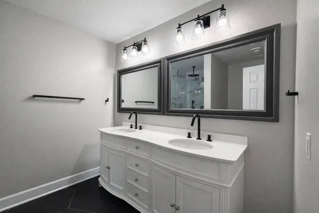 a bathroom with a double vanity sink and a mirror