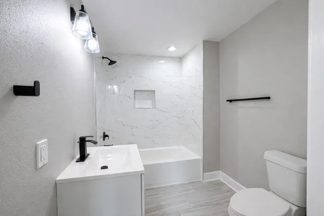 a bathroom with a sink a toilet and shower