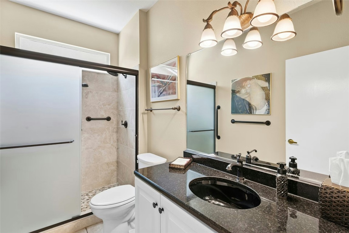 113 Coreopsis Way Georgetown, TX 78633 - Photo 19 of 34 a bathroom with a granite countertop sink toilet a mirror and shower