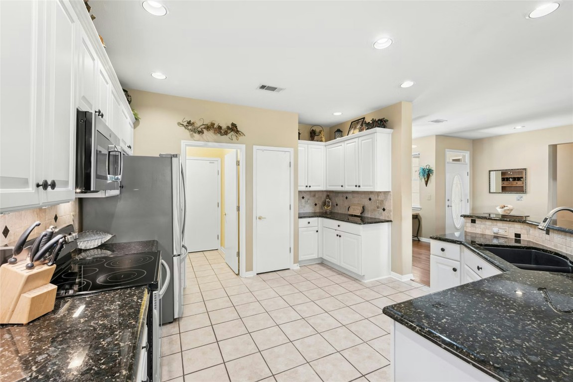 113 Coreopsis Way Georgetown, TX 78633 - Photo 7 of 34 a kitchen with granite countertop a sink and a stove top oven