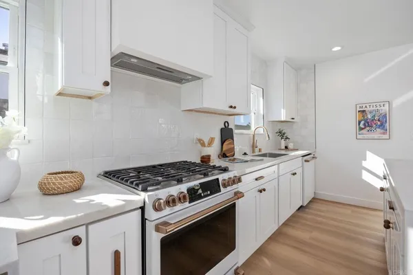 a kitchen with stainless steel appliances granite countertop a sink stove and cabinets