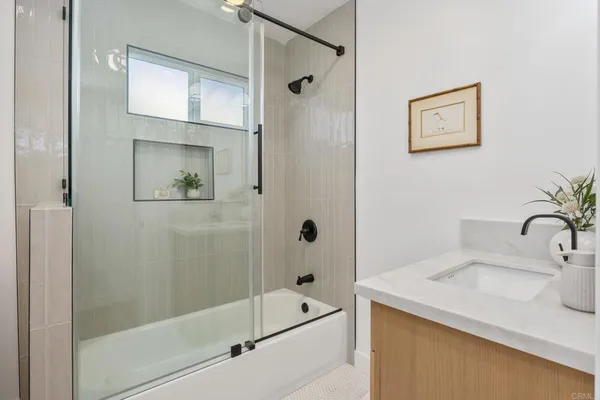 a bathroom with a granite countertop sink a mirror a shower and a bathtub
