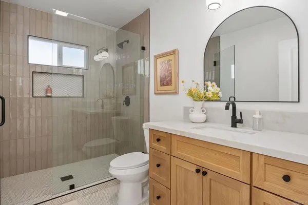 a bathroom with a glass door shower and a sink
