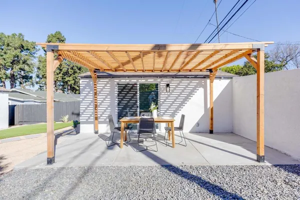 a backyard of a house with potted plants and wooden fence
