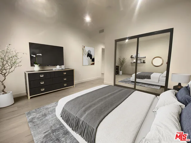 a bedroom with a bed and a flat screen tv