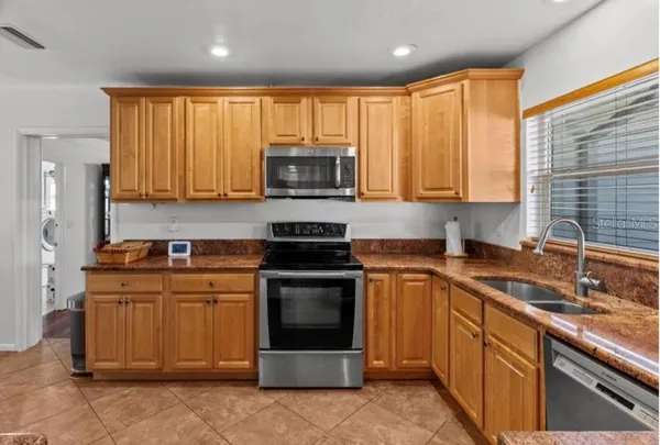 a kitchen with stainless steel appliances granite countertop a stove sink microwave and refrigerator