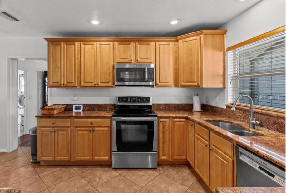 2516 Roberta Street Largo, FL 33771 - Photo 5 of 15 a kitchen with stainless steel appliances granite countertop a stove sink microwave and refrigerator