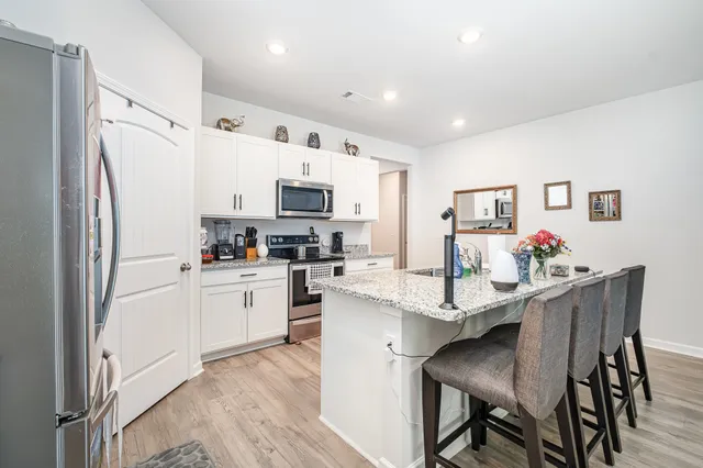 a kitchen with stainless steel appliances kitchen island granite countertop a refrigerator and microwave