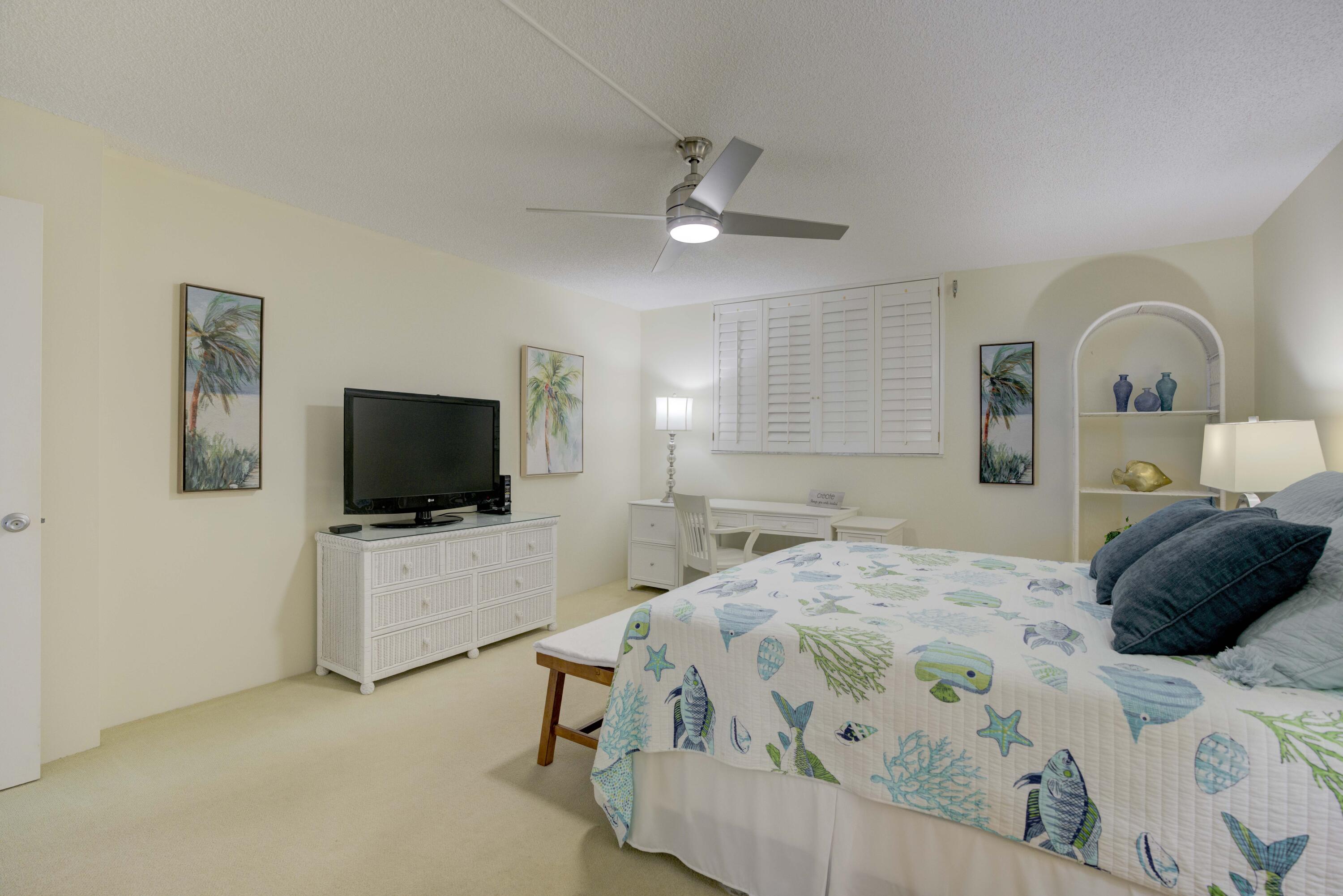 630 Ocean Drive, Unit 302 Juno Beach, FL 33408 - Photo 13 of 40 a bedroom with a bed and a flat tv screen on wall