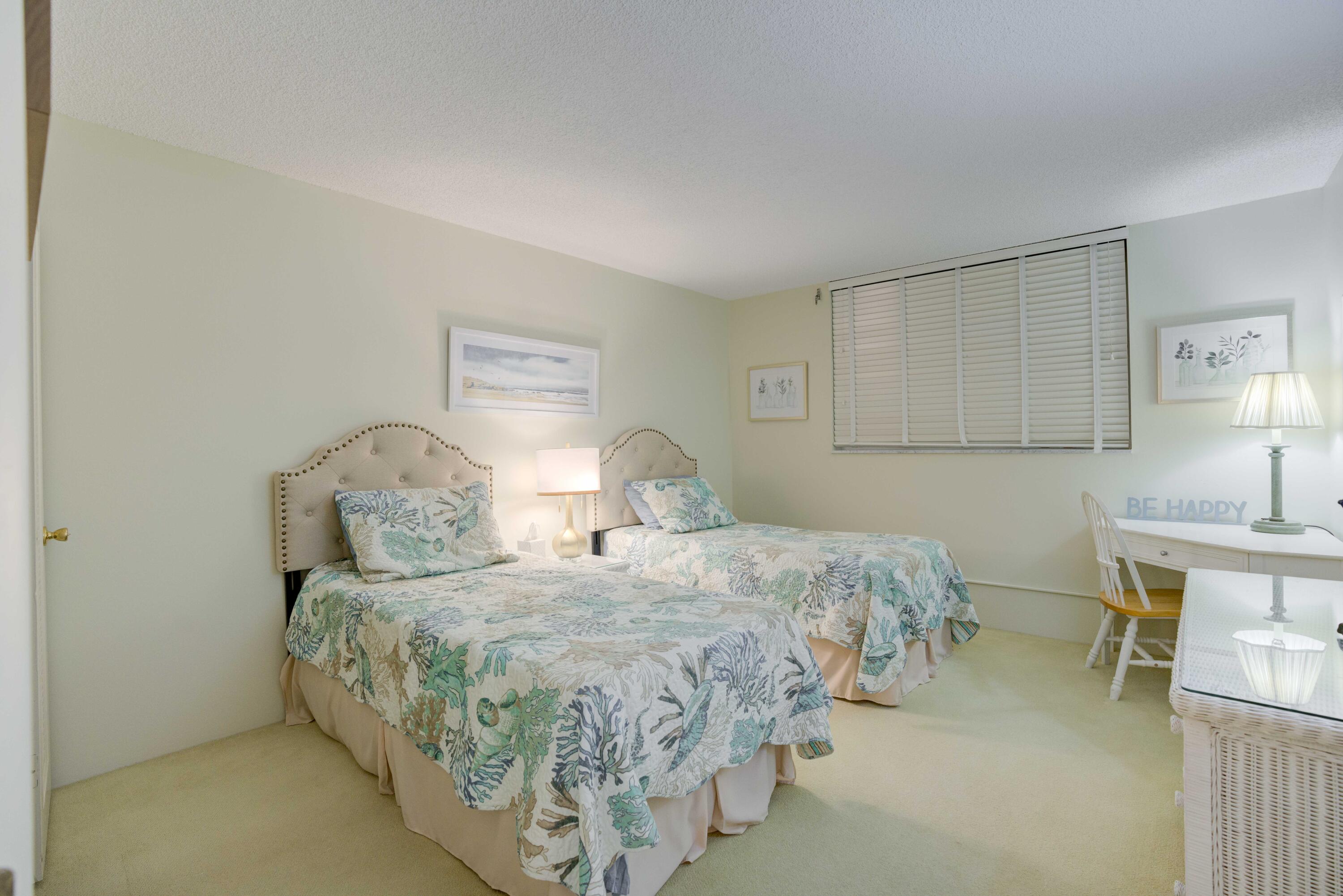 630 Ocean Drive, Unit 302 Juno Beach, FL 33408 - Photo 18 of 40 a bedroom with a bed and a table in it