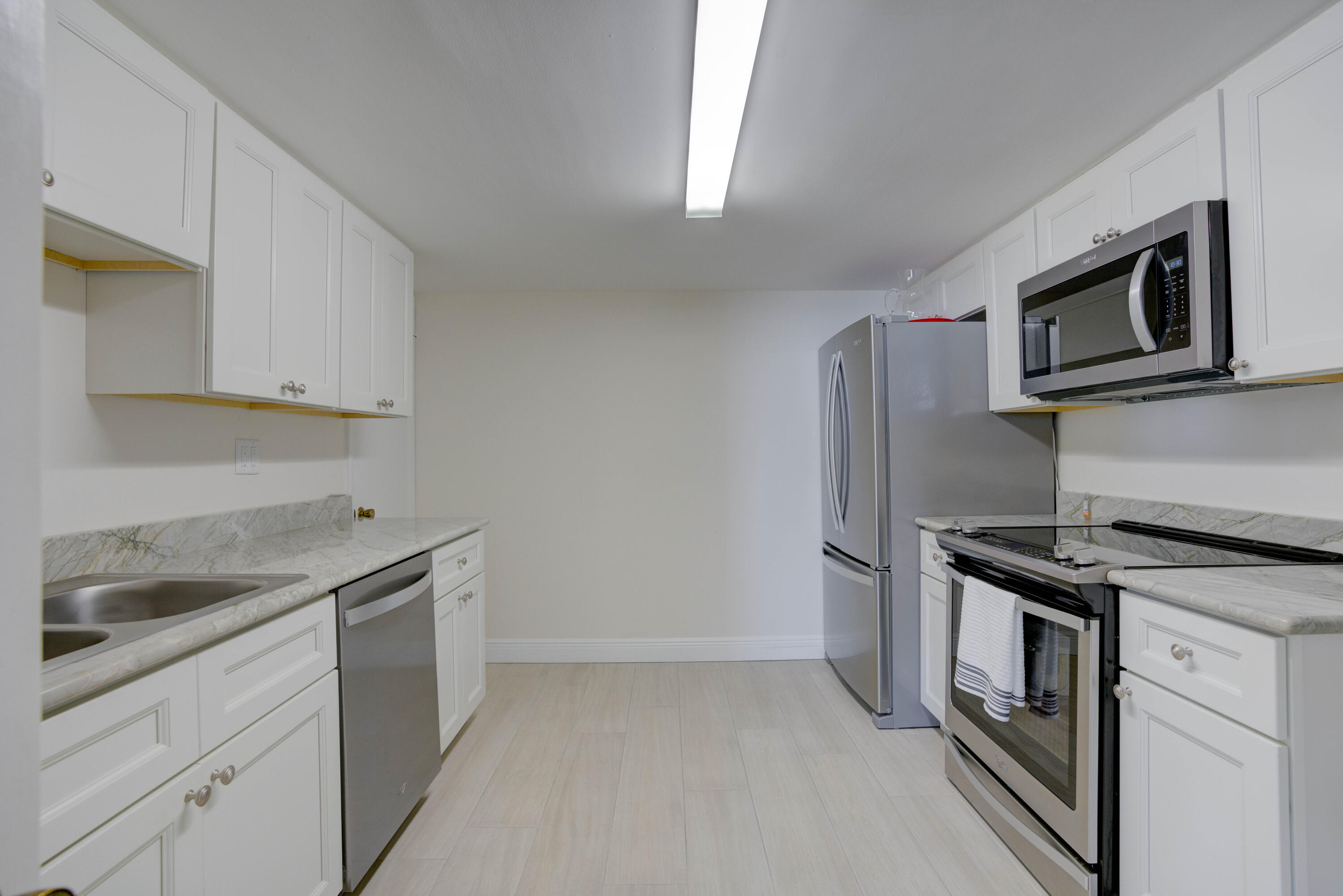 630 Ocean Drive, Unit 302 Juno Beach, FL 33408 - Photo 33 of 40 a kitchen with stainless steel appliances granite countertop white cabinets and a granite counter tops