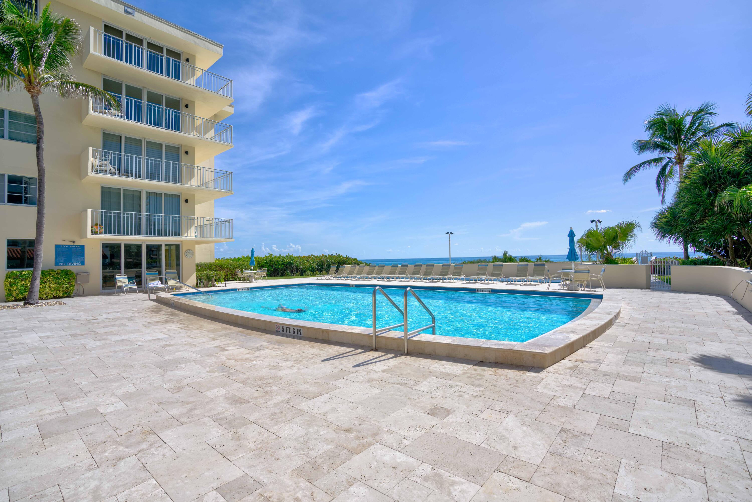 630 Ocean Drive, Unit 302 Juno Beach, FL 33408 - Photo 34 of 40 a view of a swimming pool and a yard