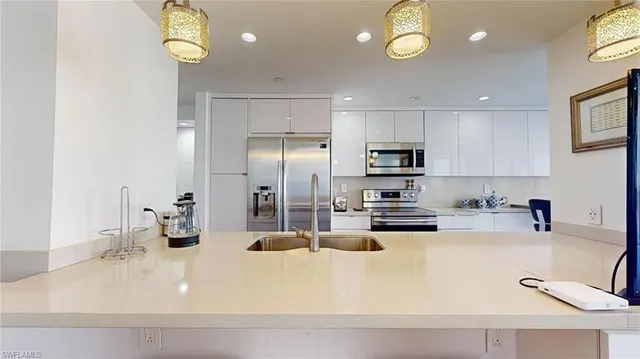 a kitchen with a sink stainless steel appliances and white cabinets