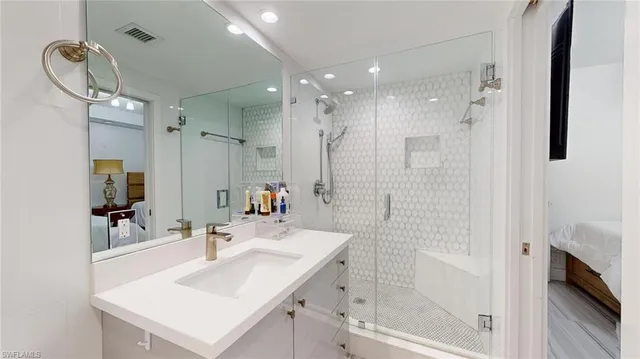 a bathroom with a sink shower and a mirror
