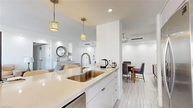 a kitchen with stainless steel appliances a table chairs and a refrigerator