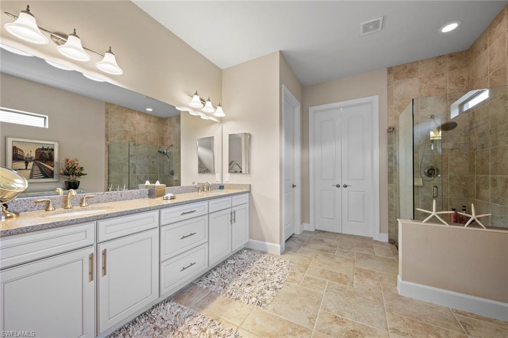 20762 Corkscrew Shores Boulevard Estero, FL 33928 - Photo 16 of 32 a spacious bathroom with a double vanity sink a mirror and a shower