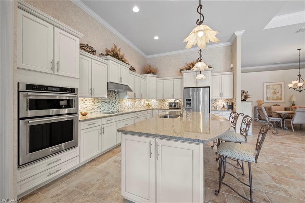 20762 Corkscrew Shores Boulevard Estero, FL 33928 - Photo 3 of 32 a kitchen with kitchen island granite countertop a sink cabinets and stainless steel appliances