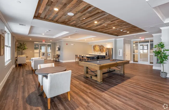 a living room with furniture a wooden floor and pool table