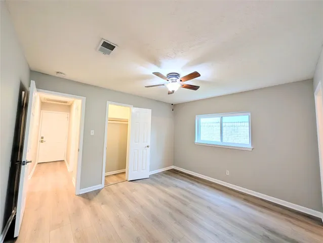 an empty room with a ceiling fan and a window