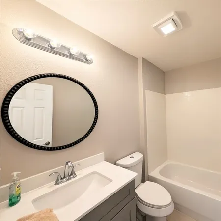 a bathroom with a sink a toilet and a mirror