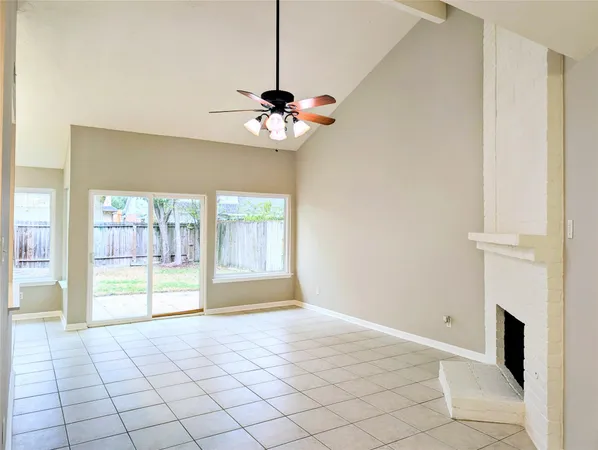a view of an empty room with a fireplace and a window