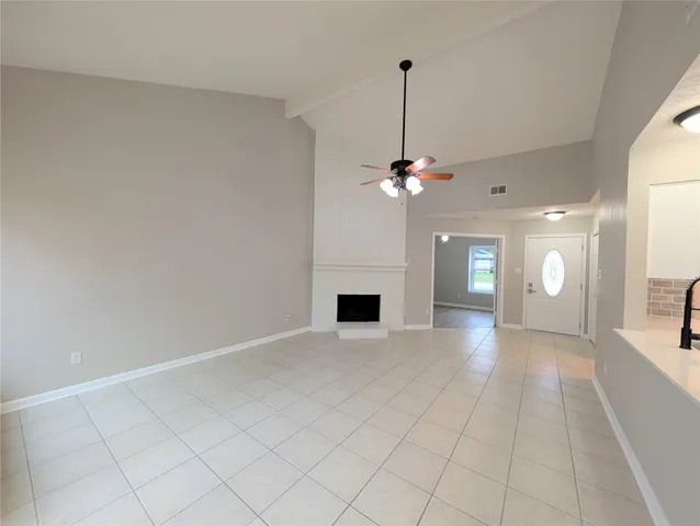 a view of a livingroom with a chandelier fan and a fireplace
