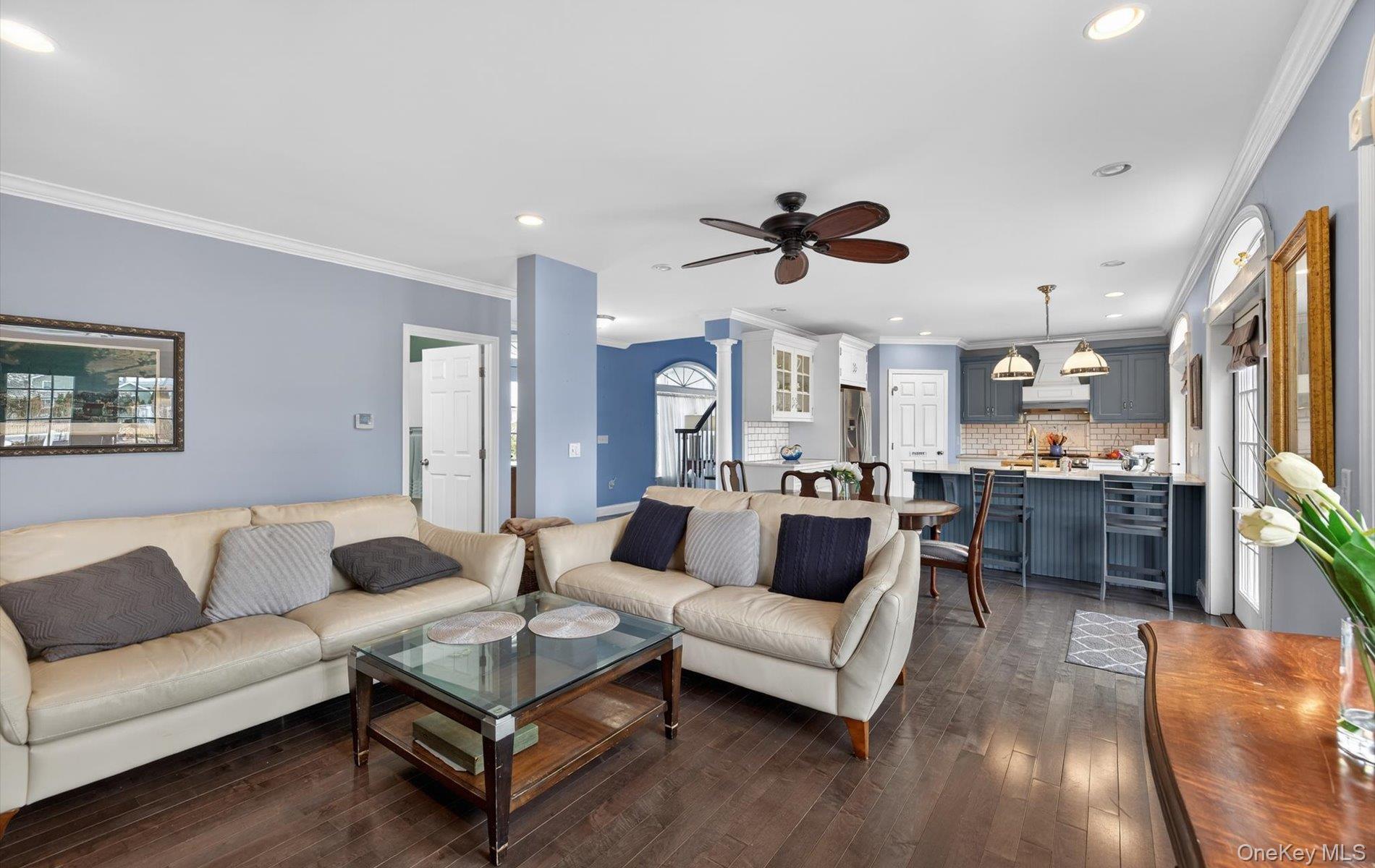 108 Awixa Avenue Bay Shore, NY 11706 - Photo 13 of 47 Living room featuring ornamental molding, a ceiling fan, dark wood-style flooring, recessed lighting, and decorative columns