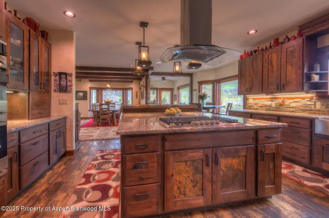 a kitchen with a stove a cabinets and wooden floor