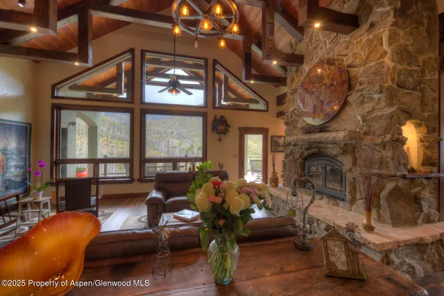 a living room with furniture a fireplace and large windows