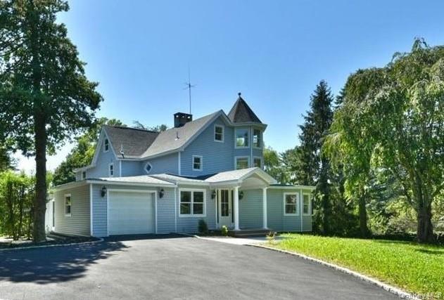 a front view of a house with yard and tress