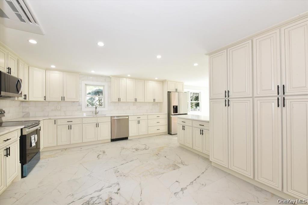 87 Dunlop Road Huntington, NY 11743 - Photo 9 of 31 a kitchen with white cabinets and white appliances