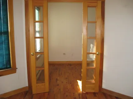 a view of a hallway with wooden floor and entryway