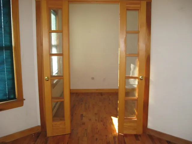 a view of a hallway with wooden floor and entryway