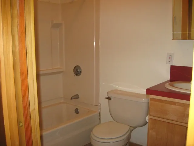 a kitchen with stainless steel appliances a sink cabinets and wooden floor