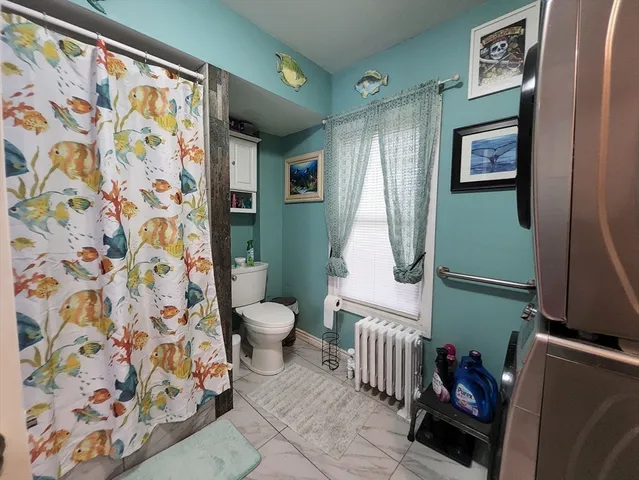 a bathroom with a toilet and a shower curtain
